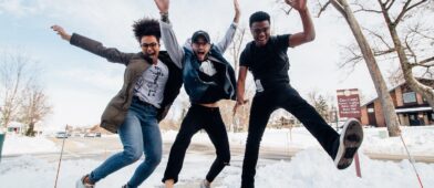 College aged kids happily jumping in the air